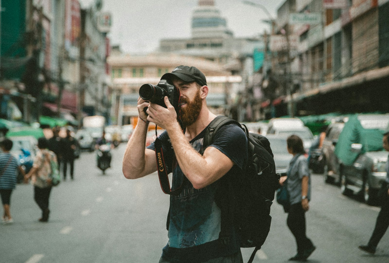 A photographer raising a camera on a busy street