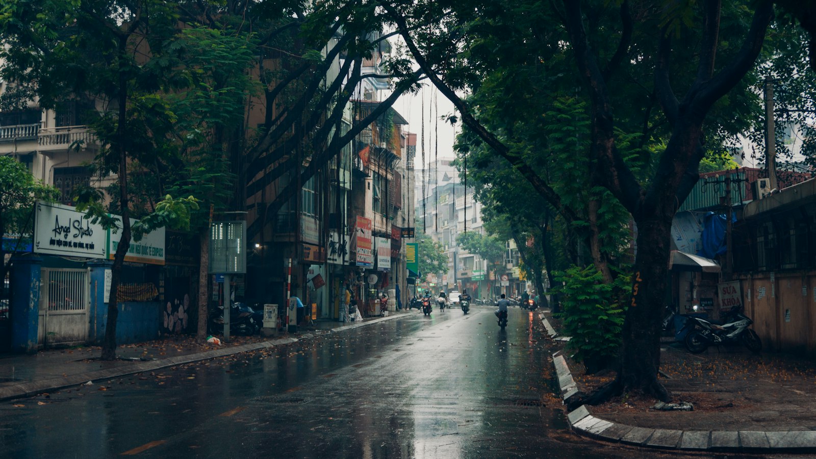 A wet small-town street lined with old shopfronts after rain