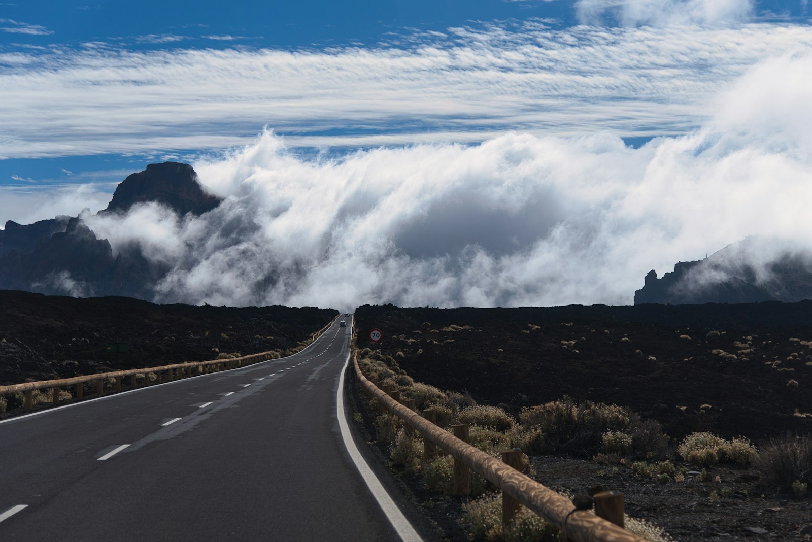 An empty road crossing high open country above the cloud line