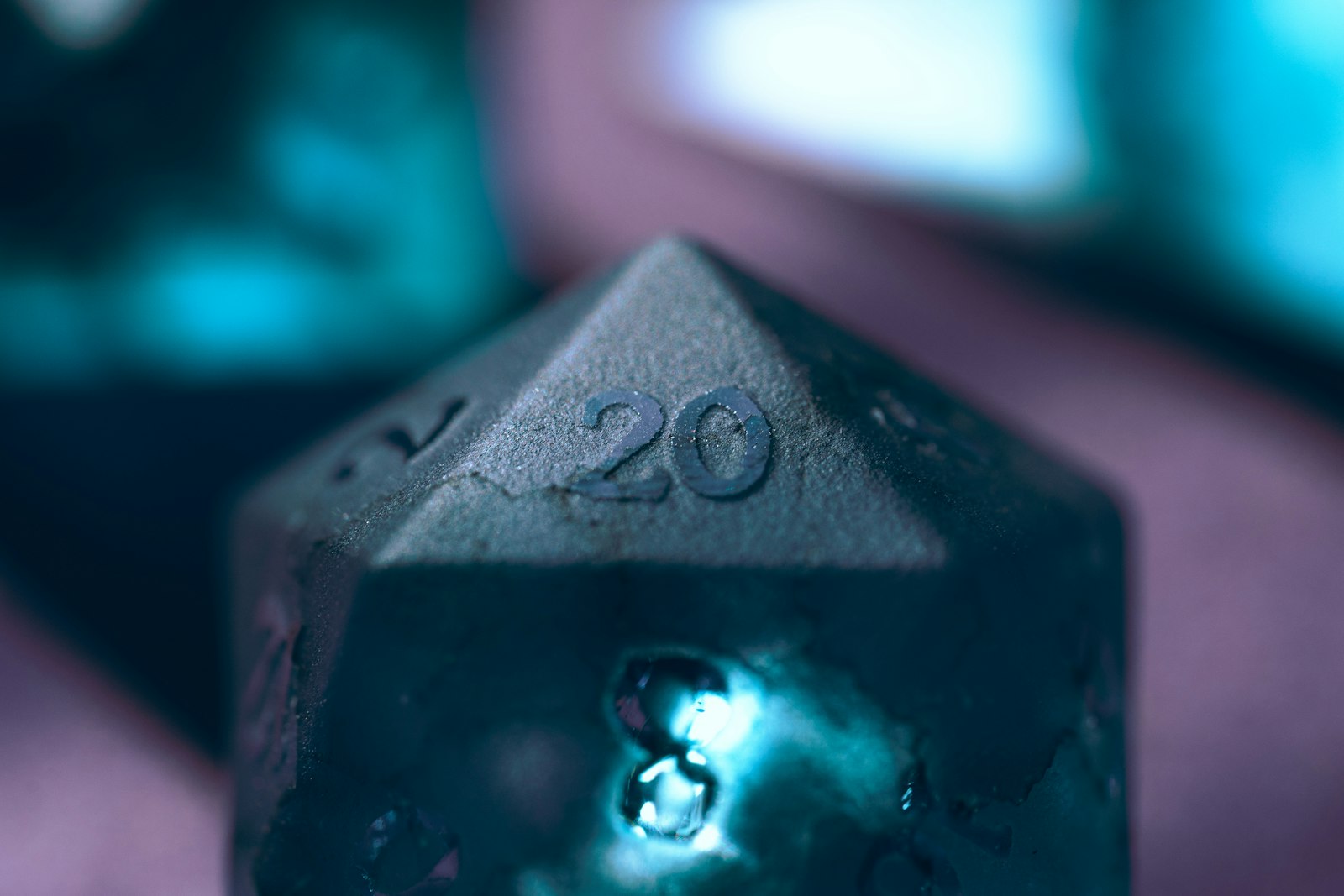 A single twenty-sided die resting on a dark surface, lit from one side.