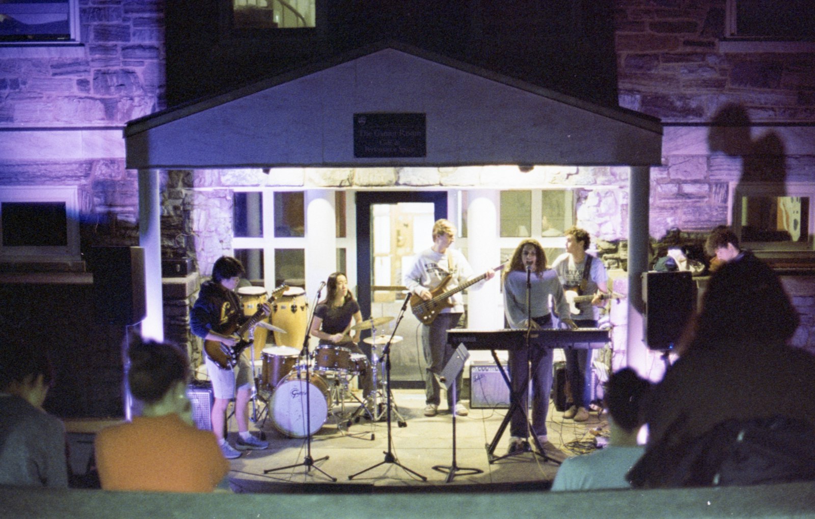 A band playing a small stage to a close crowd