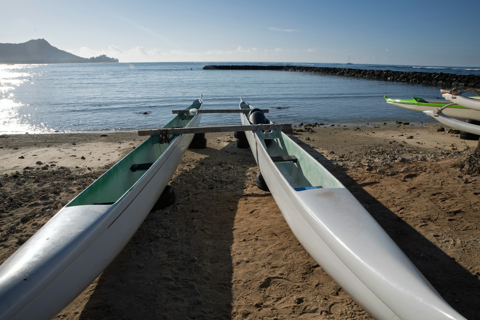 Outrigger canoes on the sand with Diamond Head in the distance