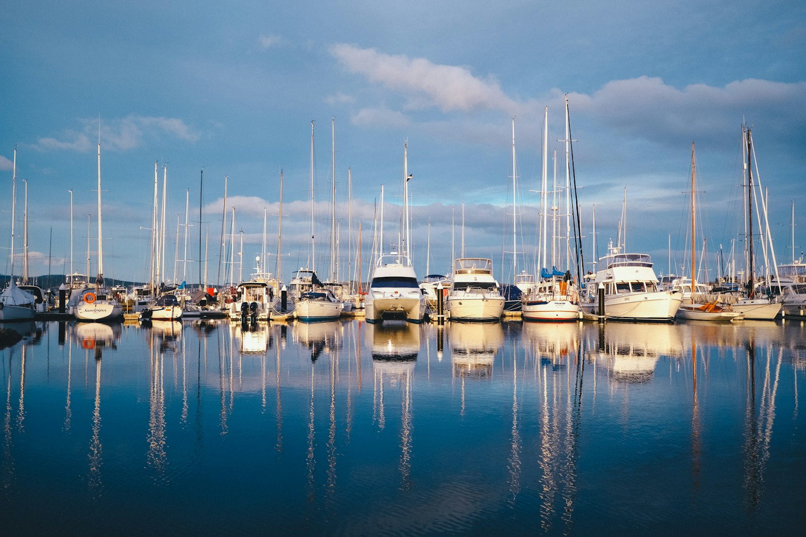 Boats moored in a calm marina under a grey sky