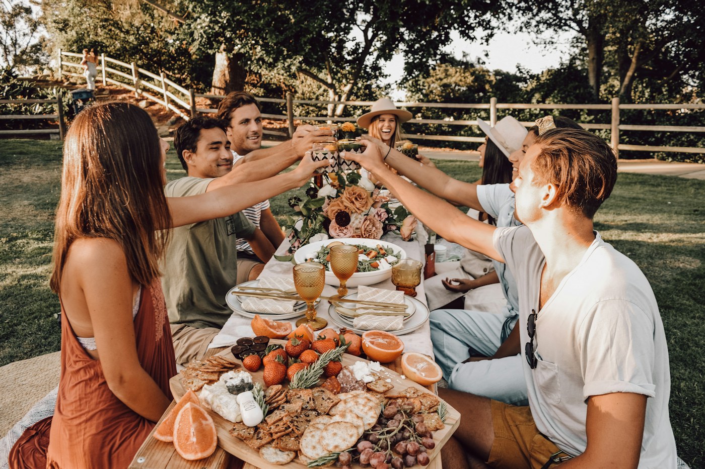 Friends sharing food and raising glasses at an outdoor table