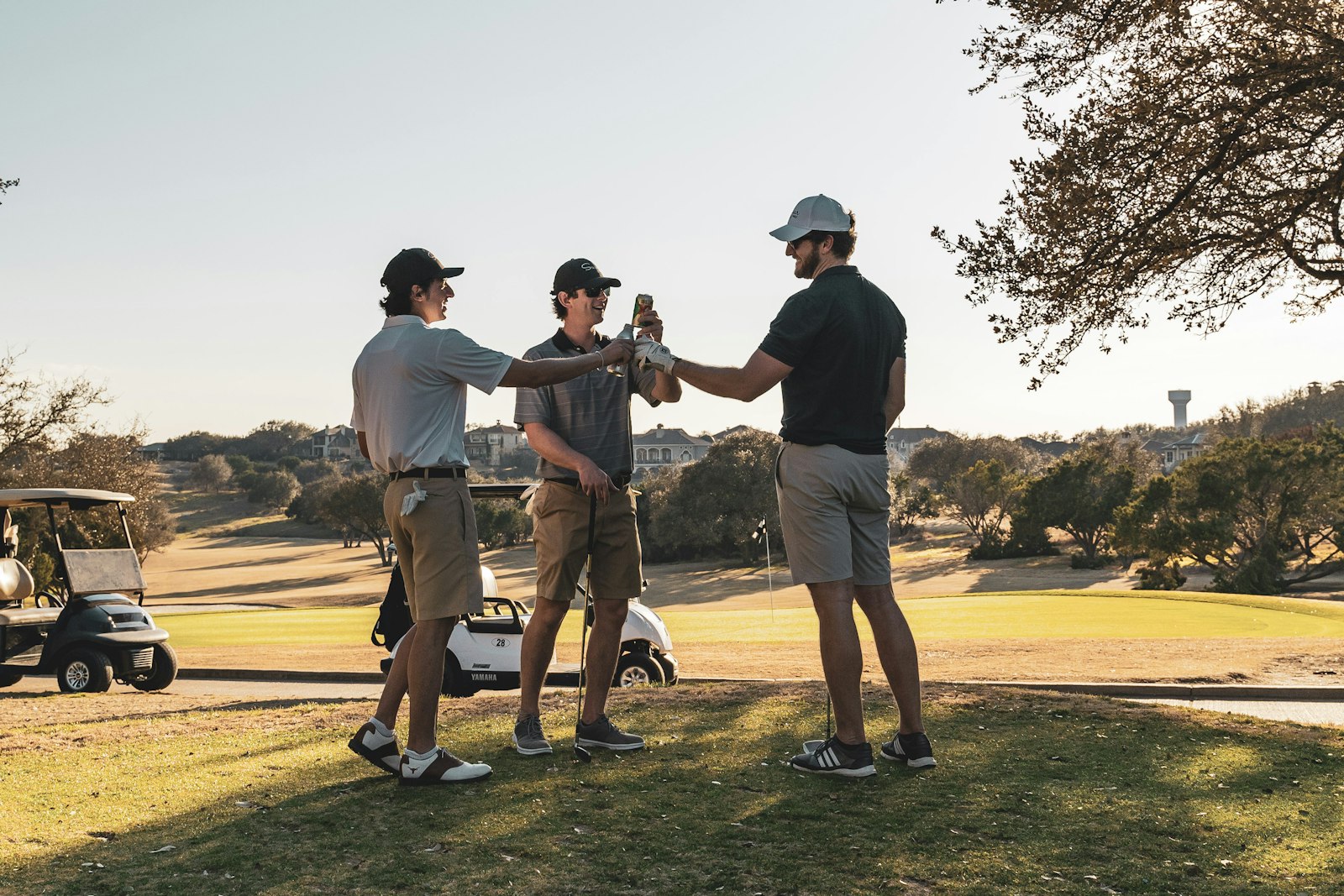 Three golfers standing together on a fairway, talking