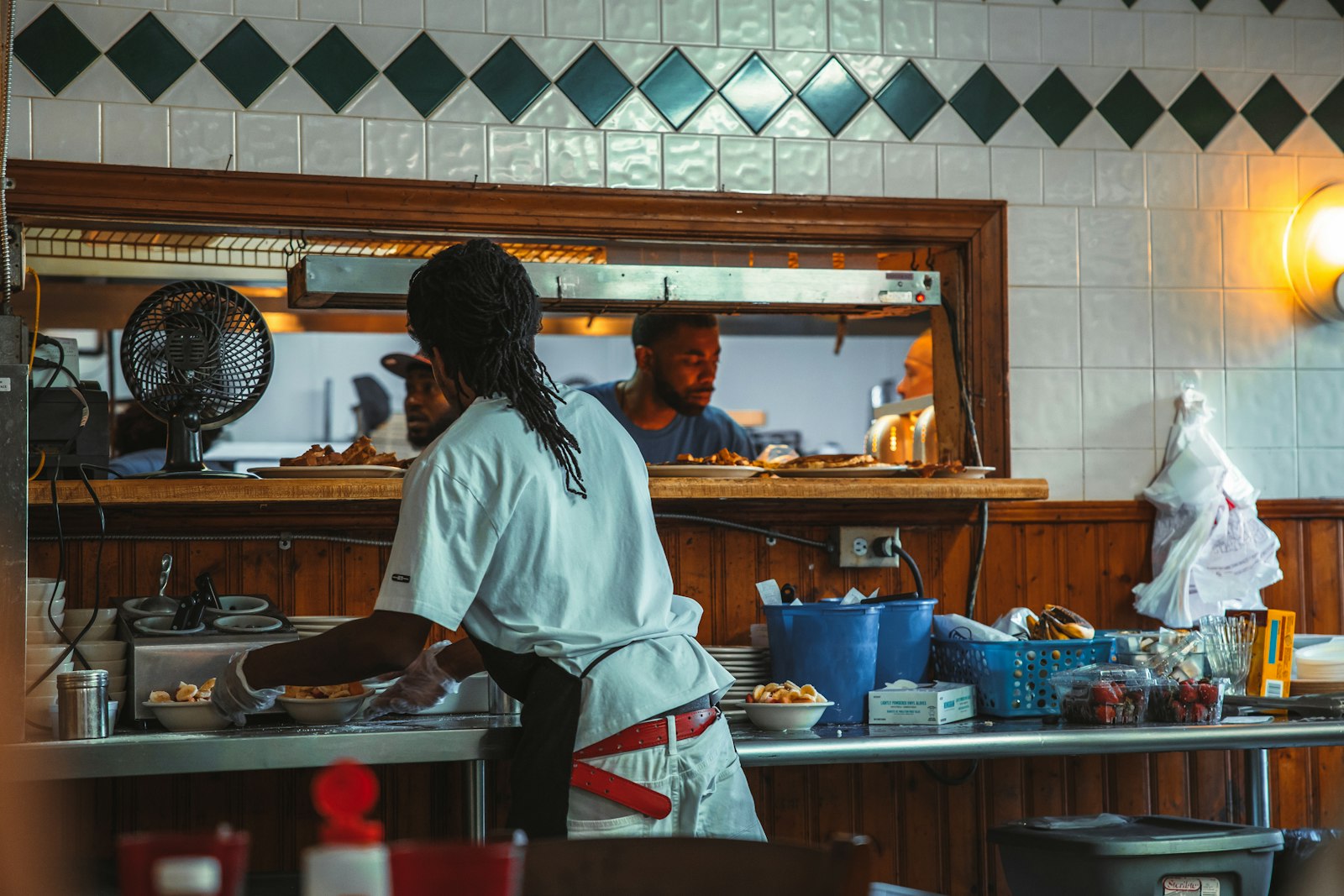 Staff working behind the counter of a small diner kitchen