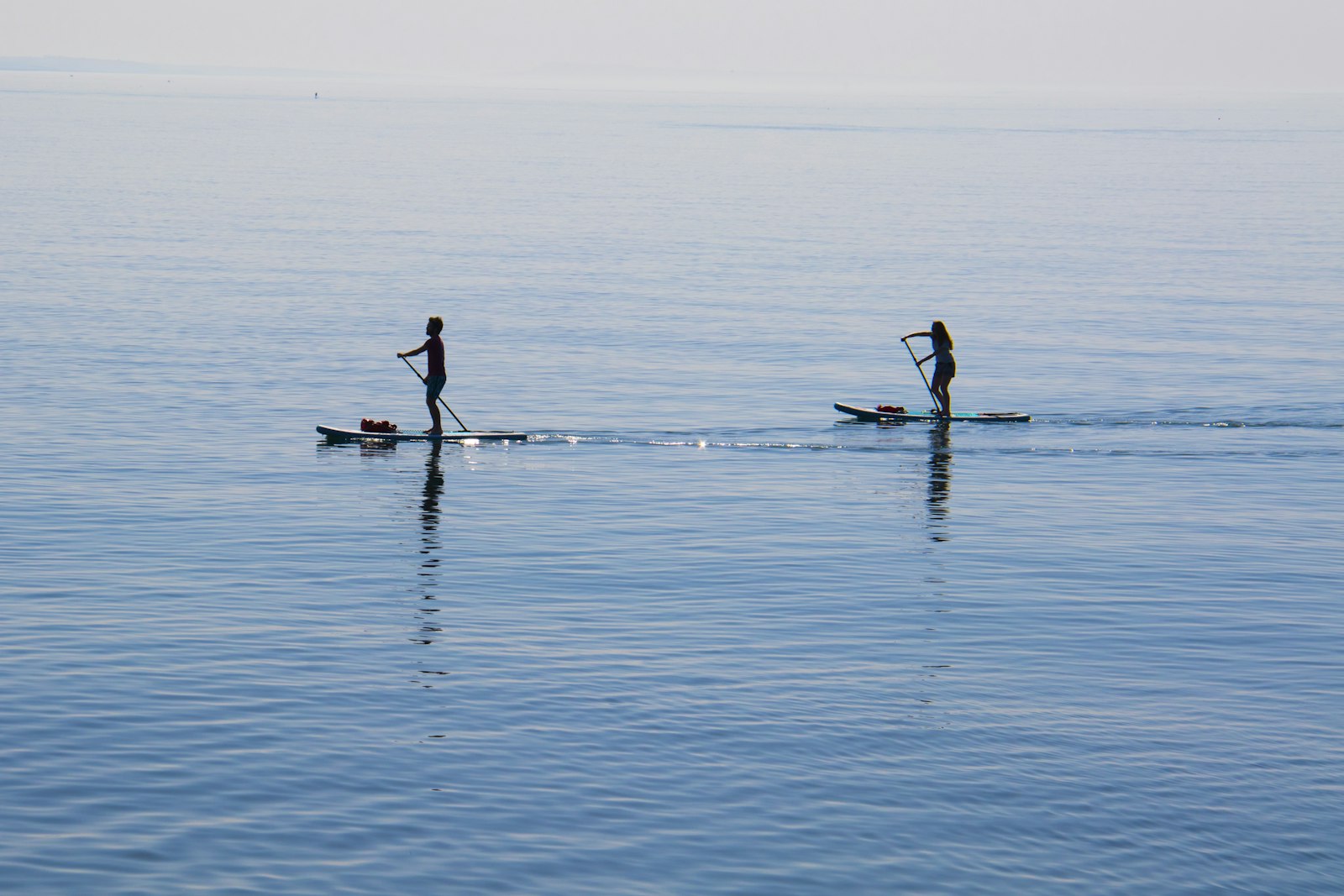 Two paddlers out on flat early-morning water