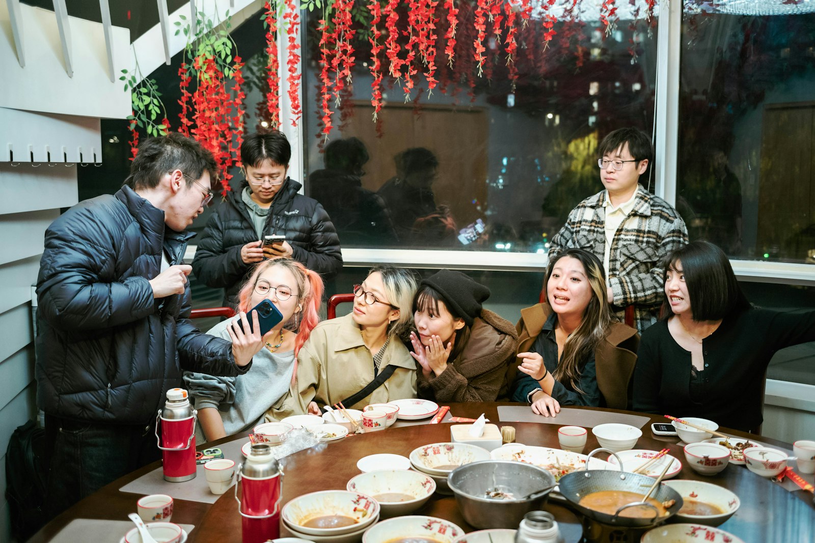 Friends around a table of food under string lights