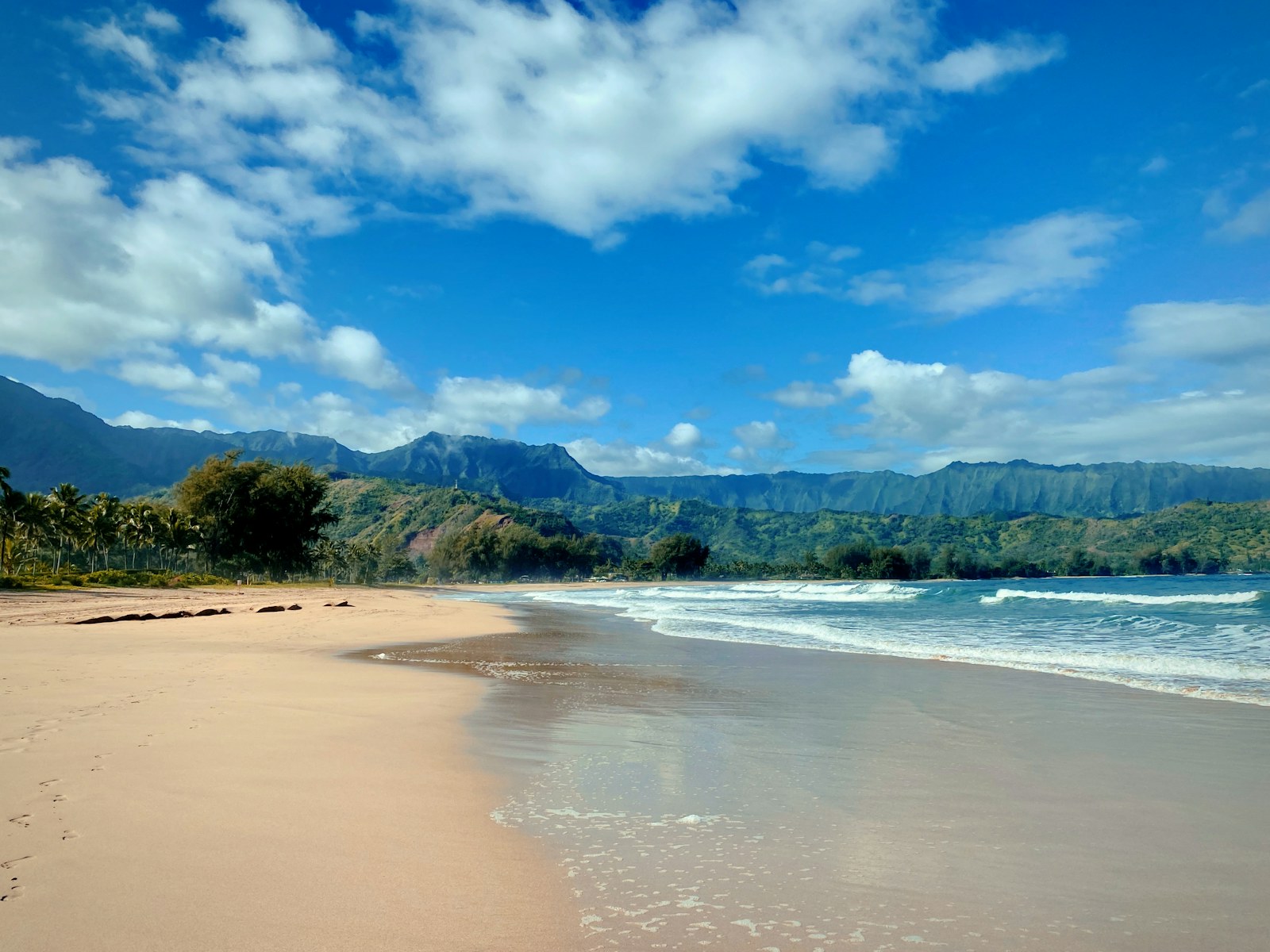 Hanalei Bay beach on Kauai with green mountains behind, a starting point for things to do on Kauai this weekend.