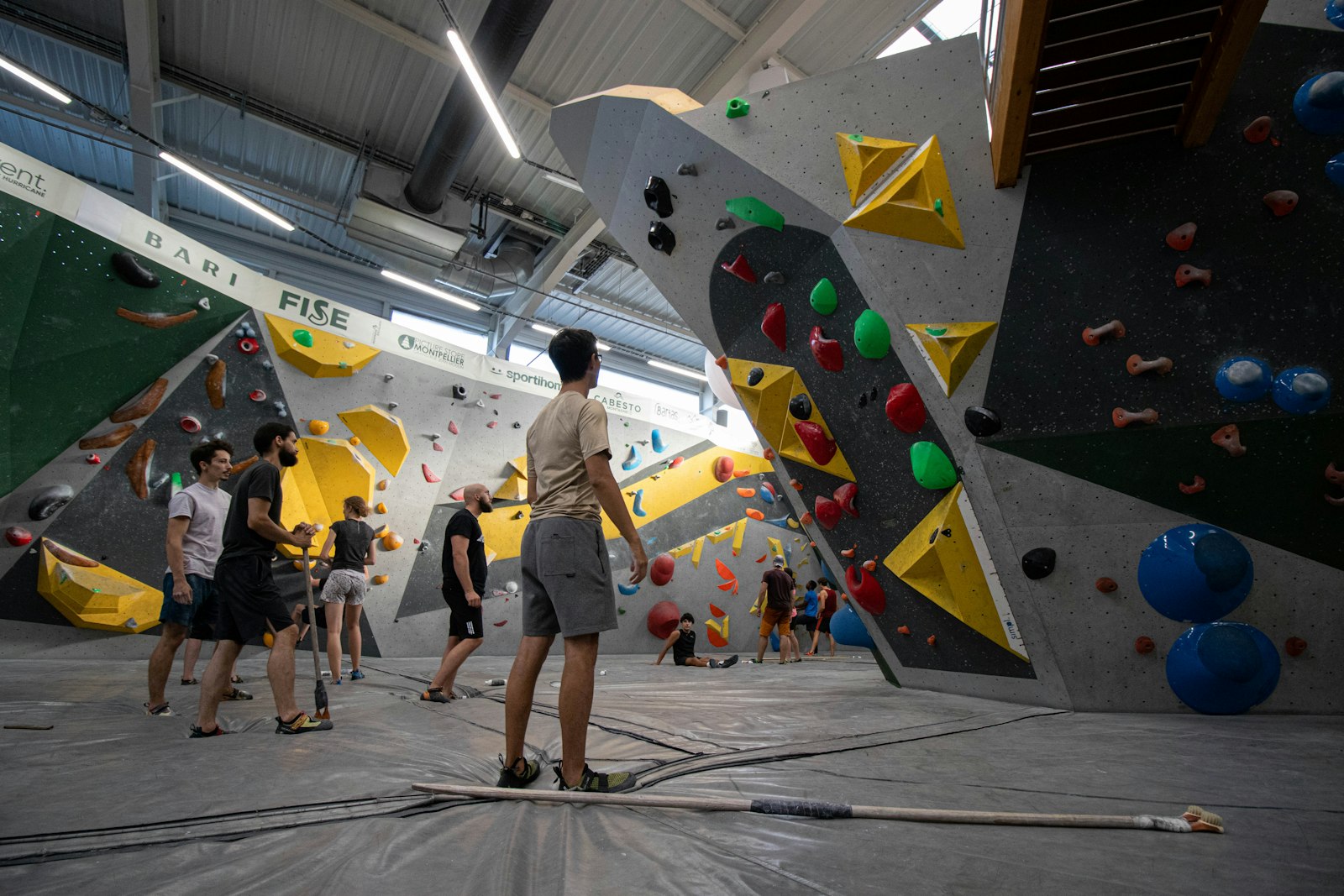 A climbing gym with people watching someone on the wall