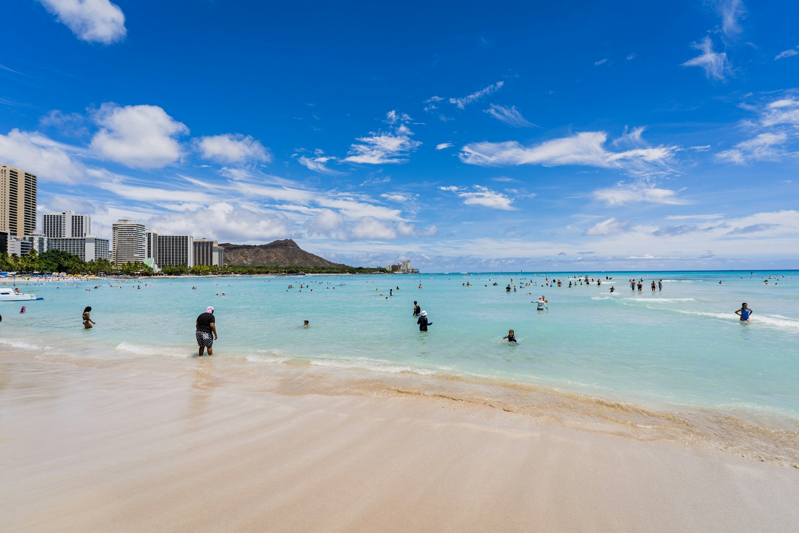 Waikiki Beach with the Honolulu skyline and Diamond Head on a sunny day, a first view for anyone moving to Oahu.