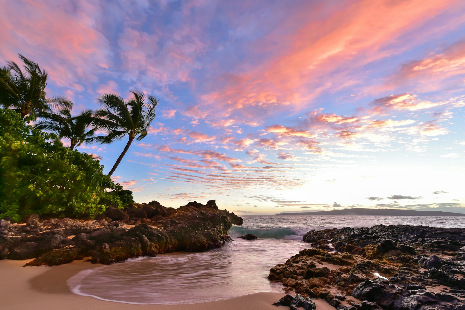 Maui coastline with green cliffs and blue ocean at golden hour